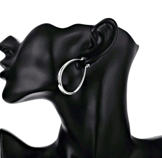 Silver hoop earring on a black mannequin ear
